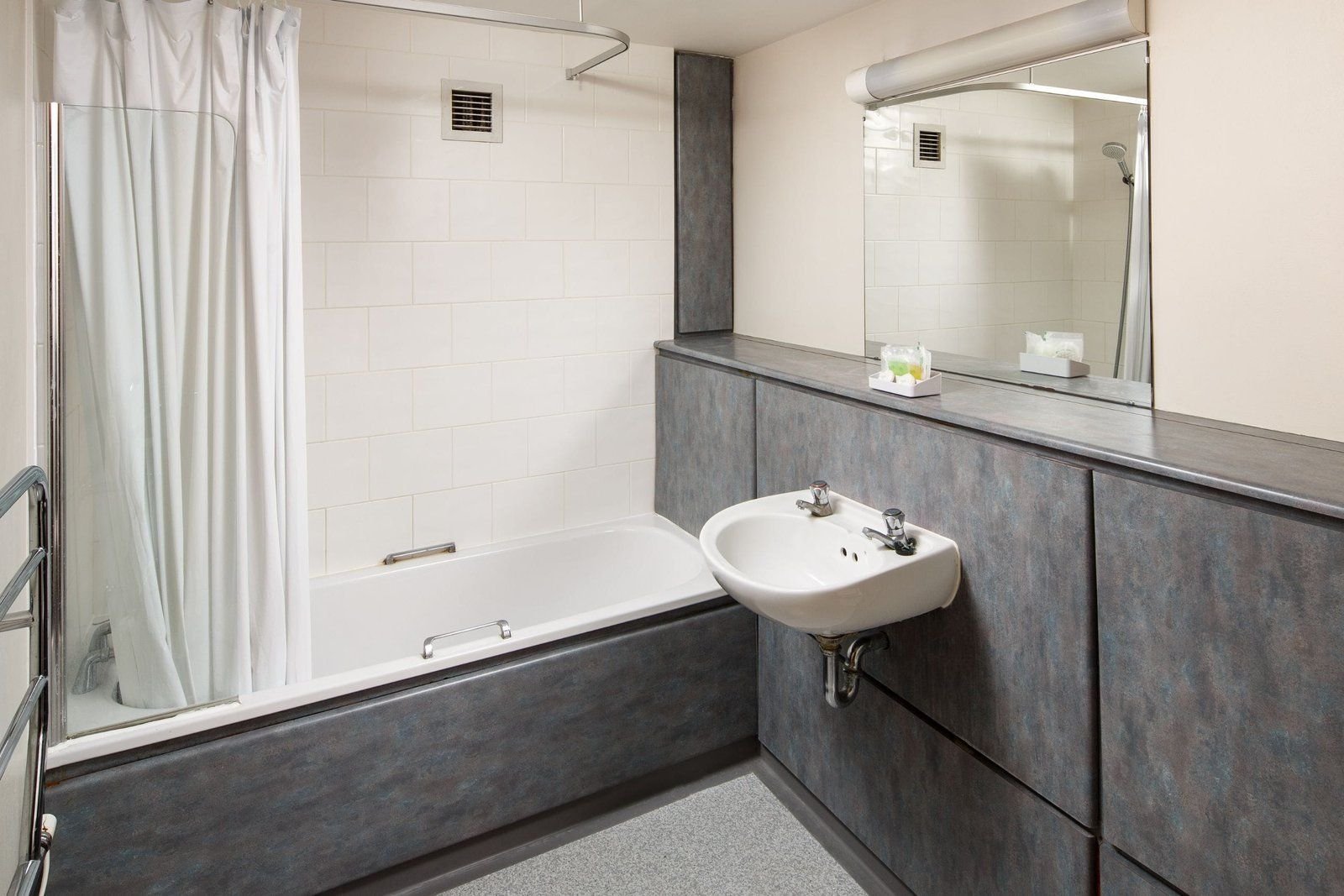 The ensuite bathroom in a 4 Stairs Building room at Christ’s College, Cambridge, with a bath and basin.