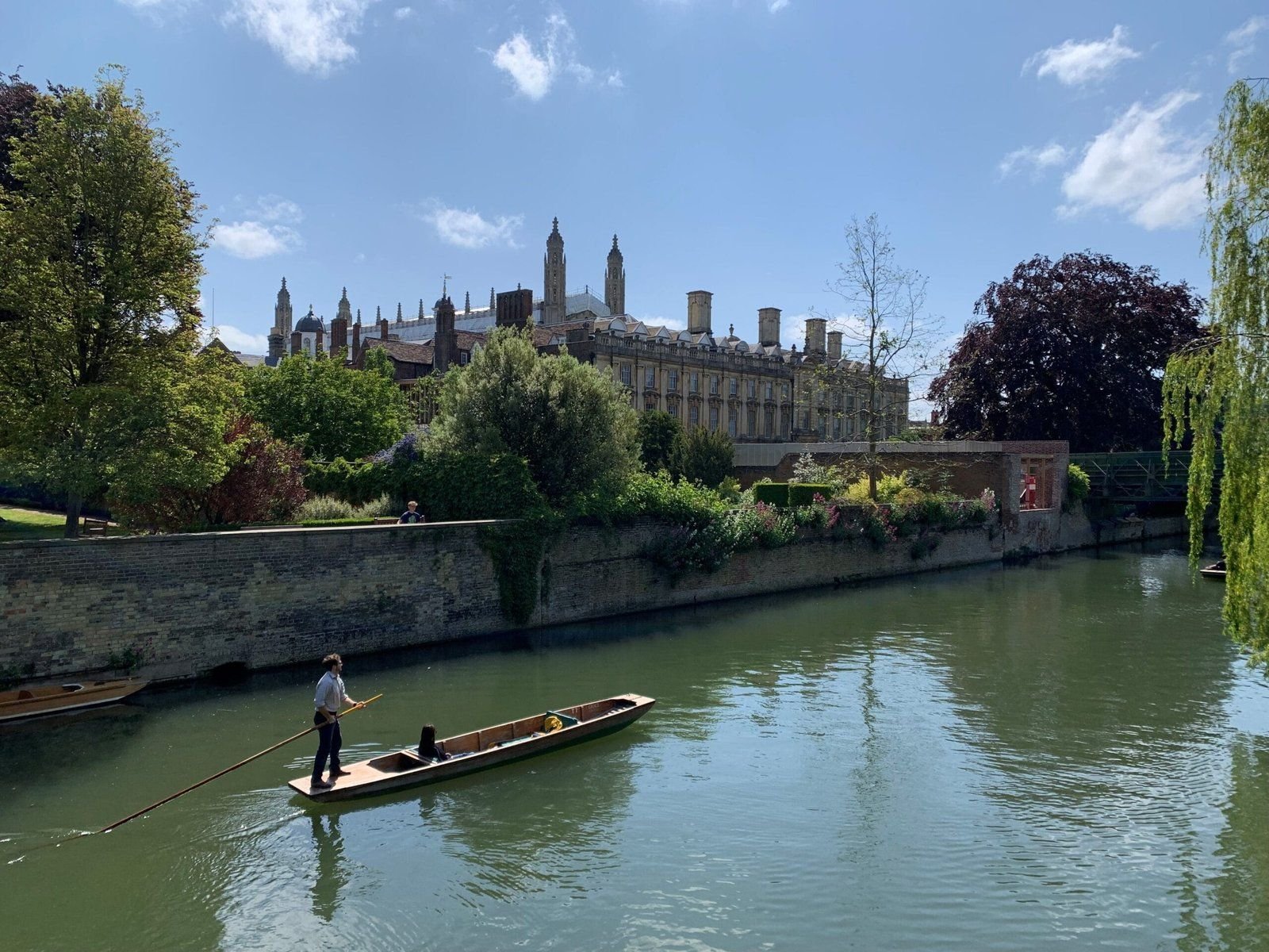 A punt gliding along the River Cam past the college lawns in Cambridge.