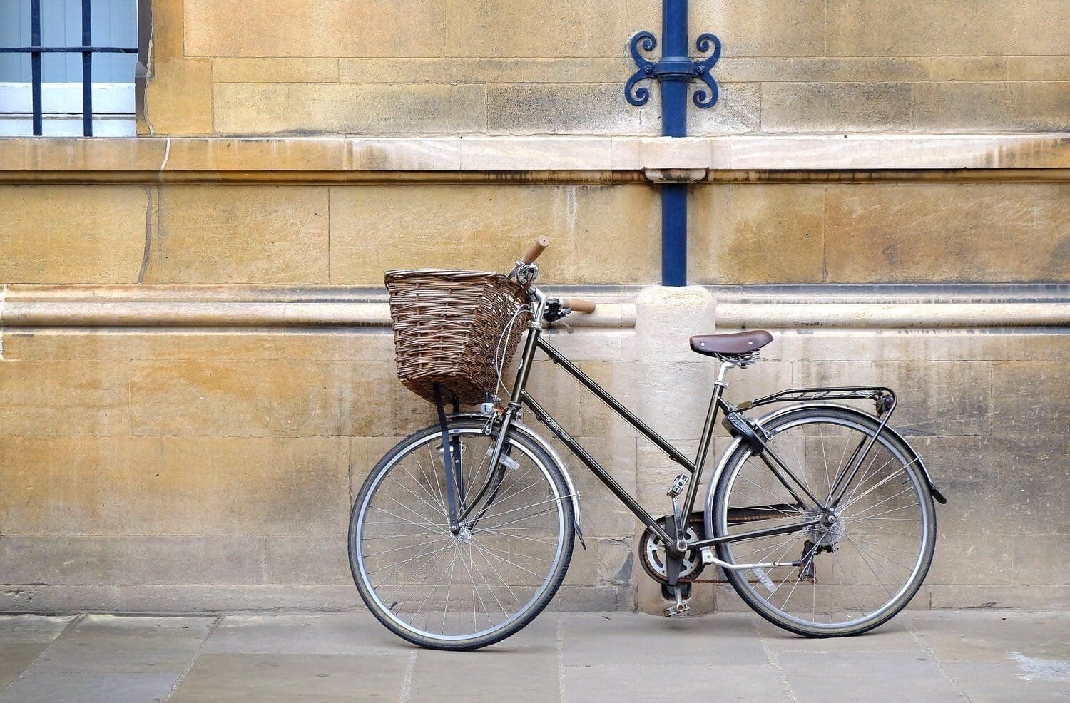 A black bike against a beige wall in Cambridge