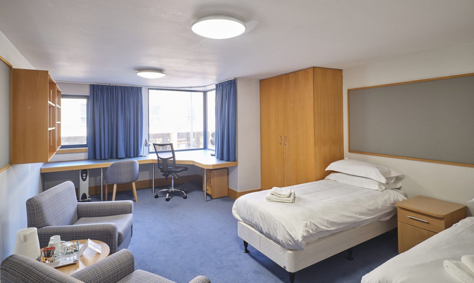 Twin ensuite guest room at Christ's College, Cambridge, with two single beds and a desk.